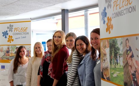 Ausbildung in der Pflege: Sieben junge Frauen blicken lächelnd in die Kamera.