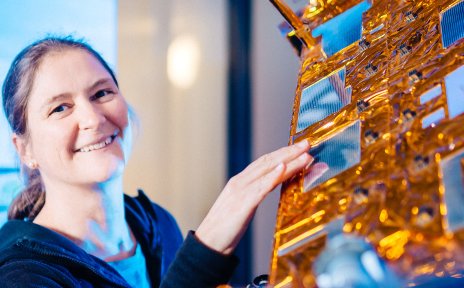 Eine Frau fasst einen Satelliten an.