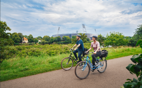 Zwei Personen auf Fahrrädern vor dem Weserstadion