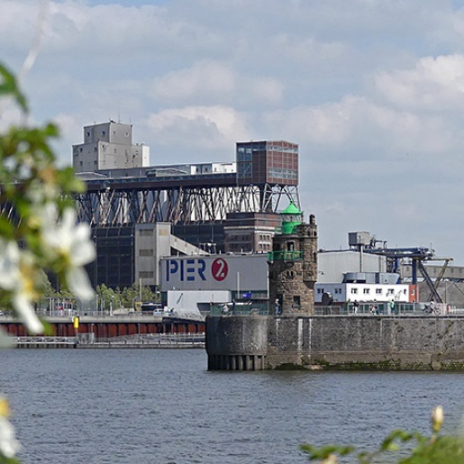 Blick über die Weser auf den Hafen mit der kolossalen Getreideverkehrsanlage, dem Pier 2 und dem Molenturm