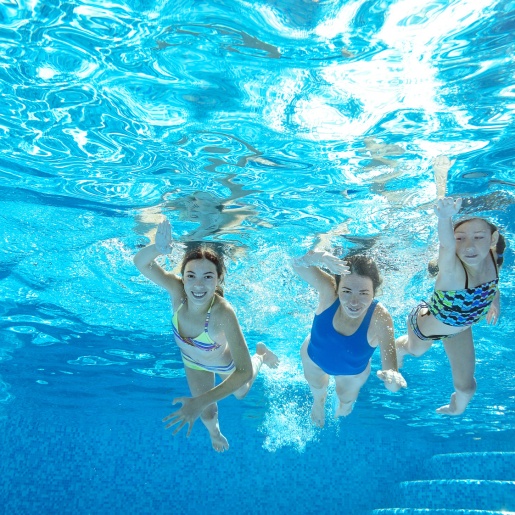 Eine Frau und zwei Mädchen aus der Unterwasserperspektive in einem Schwimmbad fotografiert. fotolia / Iuliia Sokolovska