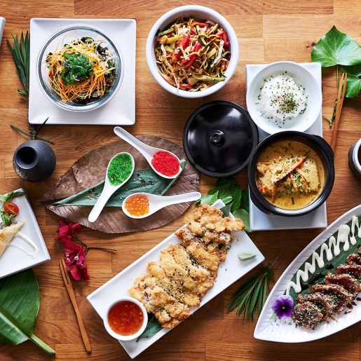 Ein gedeckter Tisch mit unterschiedlichen asiatischen Speisen wie Sushi oder Ente. 