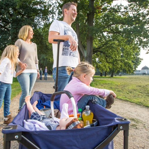 Eine junge Familie mit Bollerwagen im Park