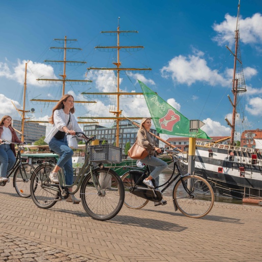 Drei Personen fahren mit dem Fahrrad an der Bremer Schlachte entlang.