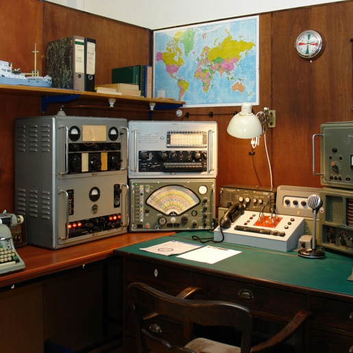 Ein Schreibtisch mit älteren Rundfunkgeräten.