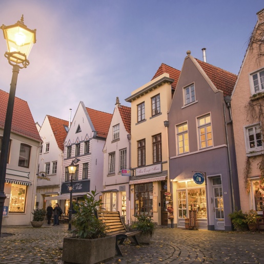 The Schnoor quarter in the evening. The lights shine in the shops. 