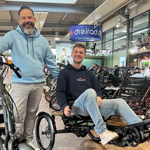 Zwei Männer präsentieren Spezialräder in einem Laden. 