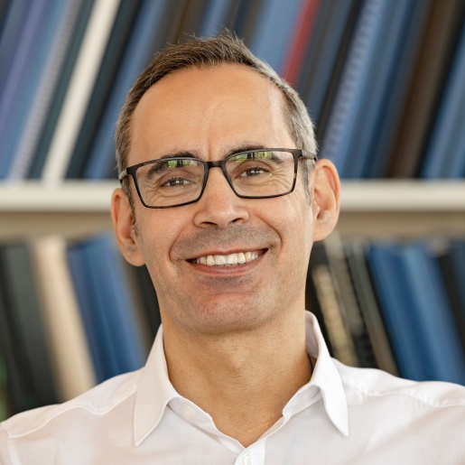 Ein Mann mit Brille lacht