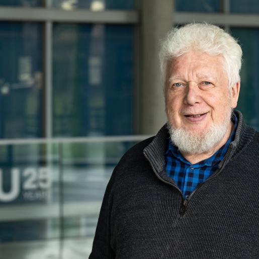 Klaus Boehnke steht im Freien vor einem Glasgebäude.