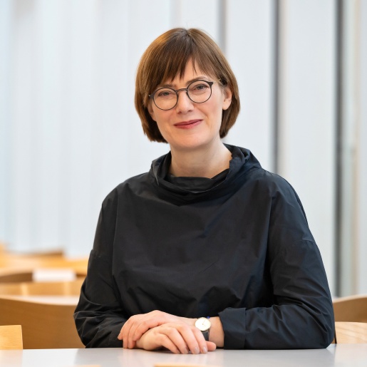 Frau mit Brille sitzt an einem Tisch