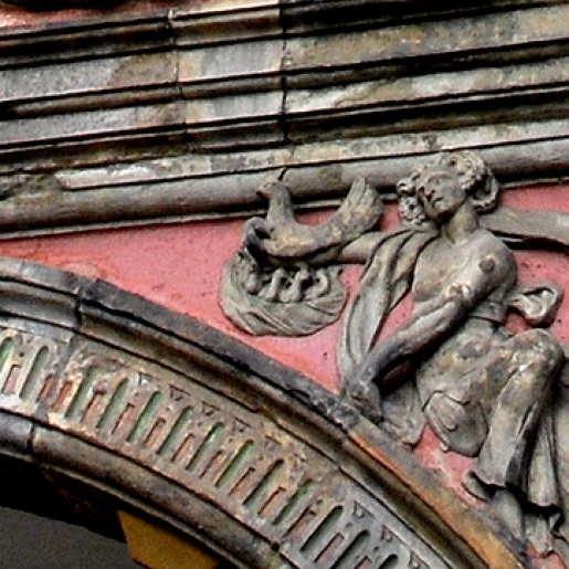 Gluckhenne mit ihren Küken über dem zweiten Arkadenbogen des Rathauses.
