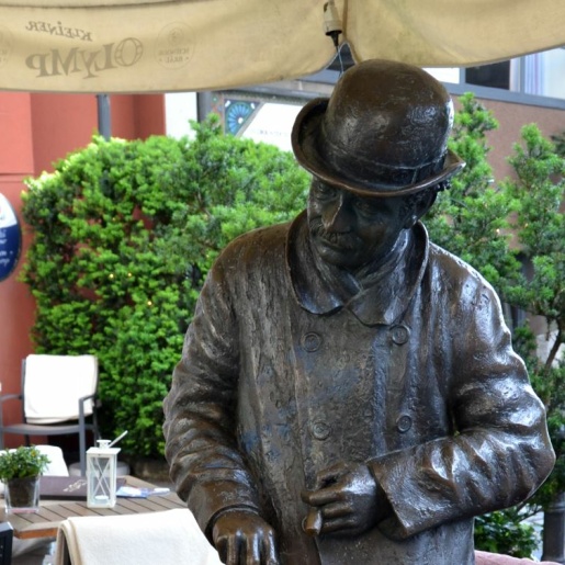 A bronze statue of a man with a hat.