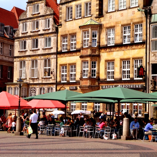 Geschäftiges Treiben bei Sonnenschein auf der Terrasse eines Straßencafés auf dem Bremer Marktplatz.