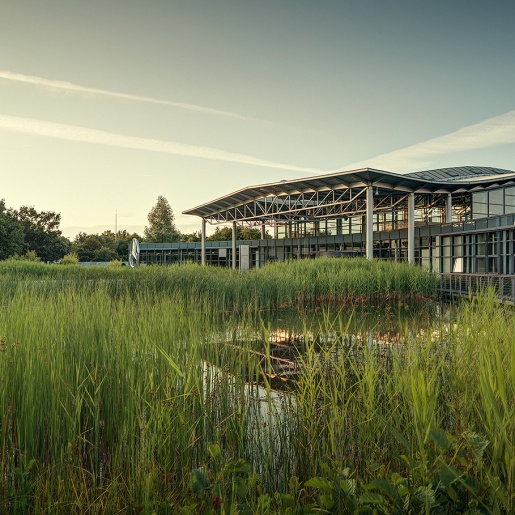 Blick auf das Gottlieb Restaurant im Mercedes Benz Kundencenter von außen mit Blick auf See.
