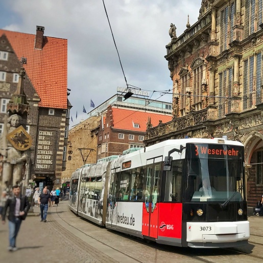Eine Straßenbahn fährt vor dem Rathaus über den Marktplatz Bremen