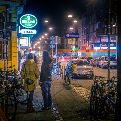 Zwei Personen stehen im Abendlicht vor der Kneipe Eisen im Viertel