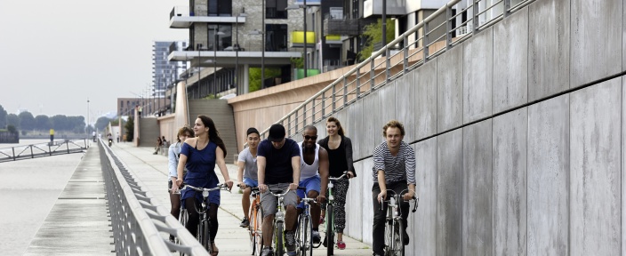 Eine Gruppe Fahrradfahrer fährt in der Überseestadt am Wasser vorbei