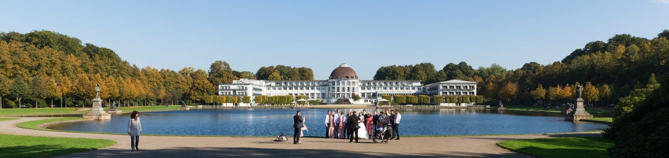 Eine Hochzeitsgesellschaft posiert für ein Foto vor dem Parkhotel.