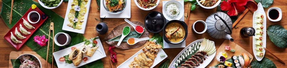 Ein gedeckter Tisch mit unterschiedlichen asiatischen Speisen wie Sushi oder Ente. 