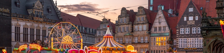 Ein Riesenrad, Buden, Lichter und Menschen auf dem Bremer Marktplatz mit historischer Kulisse.