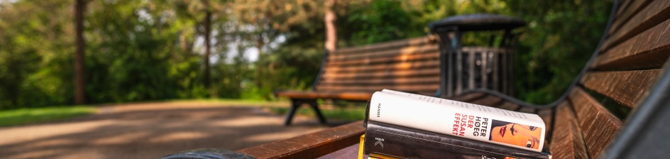 Bücher auf einer Bank in einem Park.