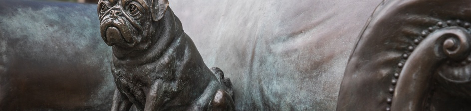 Eine Mops-Statue sitzt auf einer Couch