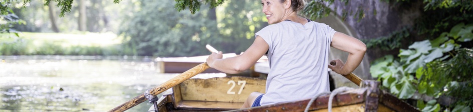 Eine Frau sitzt in einem Ruderboot. 