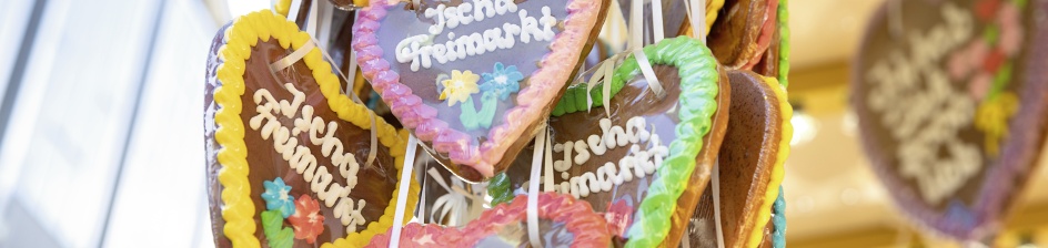 Colourful gingerbread hearts hang from a sweet stand. 