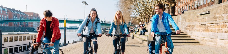 Junge Menschen fahren an der Weser Fahrrad