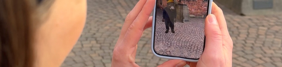 Eine Frau hält ein Handy in die Luft.