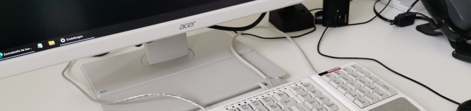 Ein Computerarbeitsplatz mit Monitor, Tastatur und Telefon. 