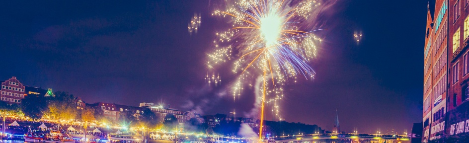 Die Schlachte ist bunt beleuchtet und ein Feuerwerk fliegt in den Himmel. 