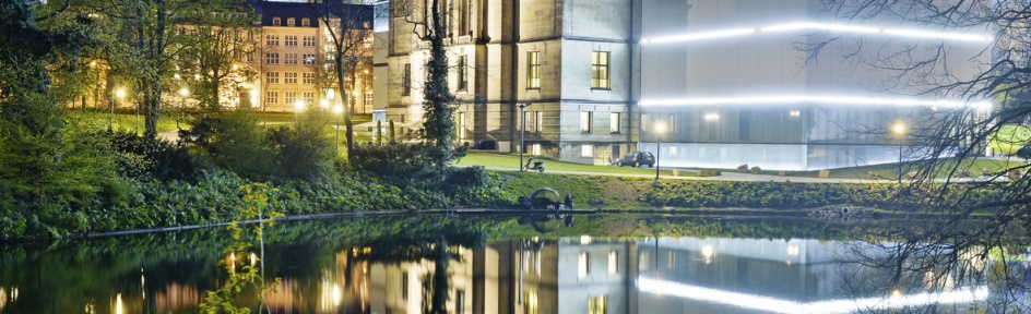 Blick auf das die beleuchtete Kunsthalle bei Nacht mit dem historischen Gebäudeteil und dem modernen Anbau