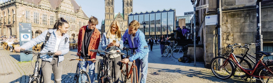 Eine Gruppe junger Menschen ist mit ihren Fahrrädern in der Bremer Innenstadt unterwegs. 