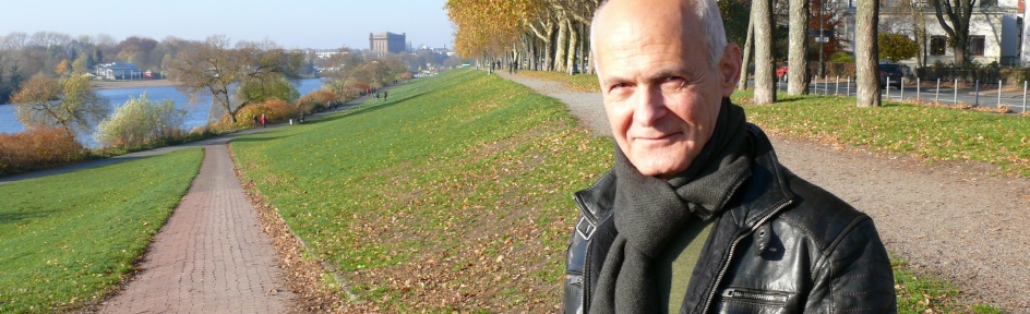 Mehmet Altun lächelt in die Kamera. Er steht auf einer Grünfläche.