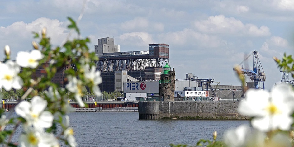 Blick über die Weser auf den Hafen mit der kolossalen Getreideverkehrsanlage, dem Pier 2 und dem Molenturm