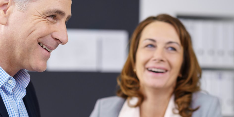 Zwei Frauen und ein Mann lachend in einem Geschäftsgespräch (Quelle: fotolia / contrastwerkstatt)