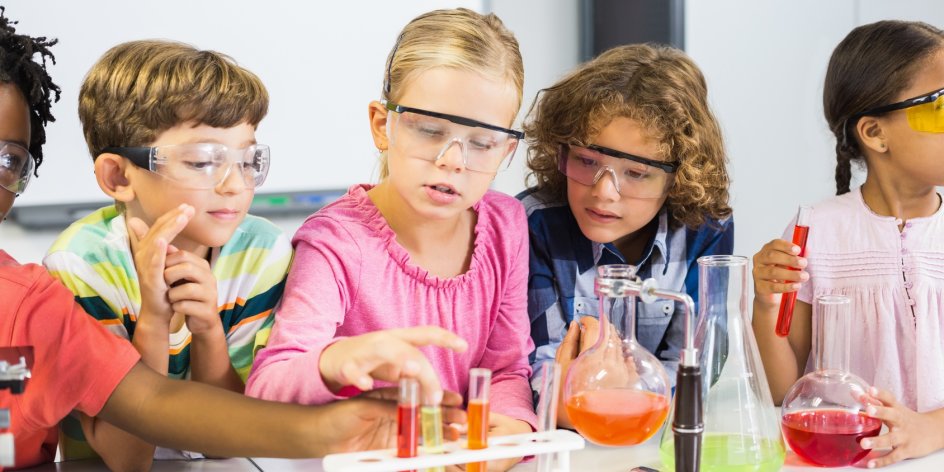 Schulkinder experimentieren im Chemieunterricht