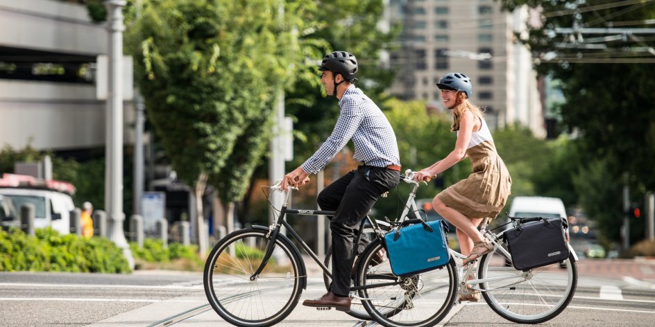Zwei Menschen fahren mit dem Fahrrad zur Arbeit