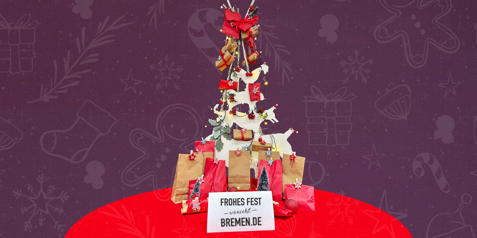 Ein festliches Bild mit einem Weihnachtsbaum mit den Bremer Stadtmusikanten, der mit kleinen Geschenkpaketen und roten Schleifen geschmückt sind. Unter dem Baum befinden sich Papiertüten und Geschenkverpackungen in Rot und Braun, die als Adventskalender mit Zahlen beschriftet sind. Ein Schild vor dem Arrangement trägt die Aufschrift „Frohes Fest wünscht Bremen.de“. Der Hintergrund ist lila mit weihnachtlichen Symbolen wie Schneeflocken, Sternen und Geschenkboxen.