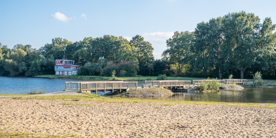 Achterdieksee mit Brücke, Strand und DLRG Station.