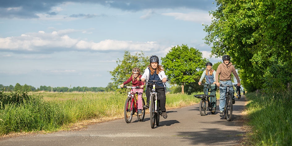 Kinder bei einer Fahrradtour im Grünen. 