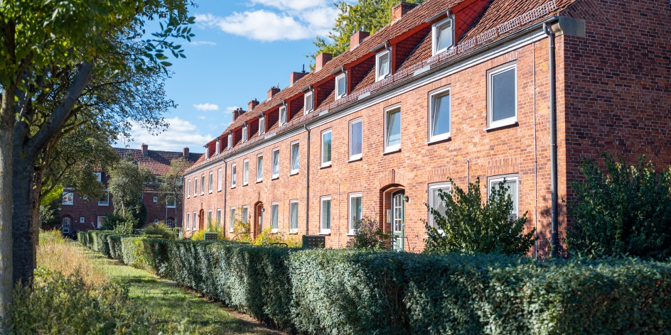 Eine Straße mit Hecken und alten Backsteinhäusern in Bremen Gröpelingen