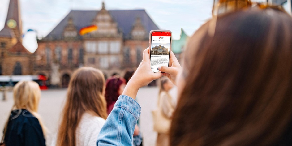 Blick durch ein Smartphonebildschirm auf den Marktplatz, der Marktplatz ist verschwommen 
