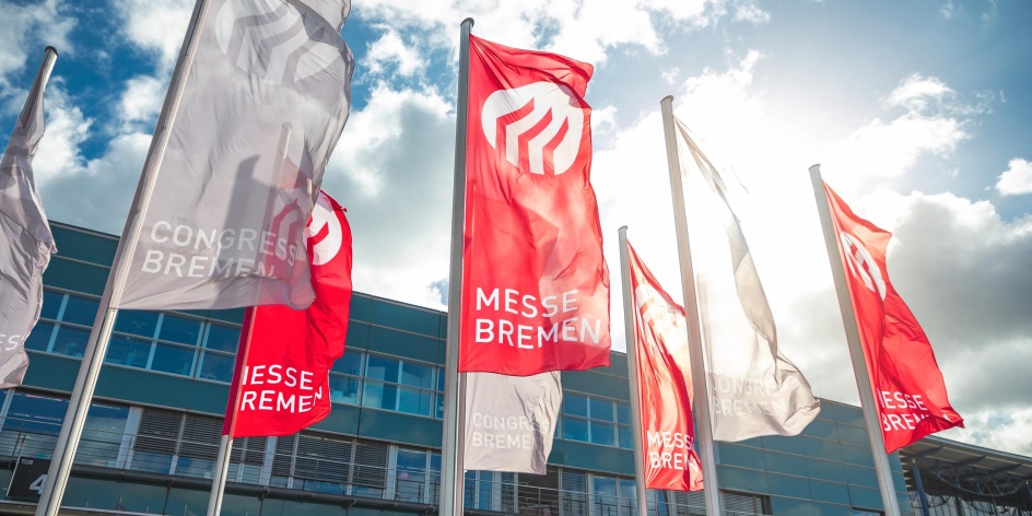 Vor dem Congress Zentrum Bremen wehen rote Fahnen mit dem Logo des Standortes