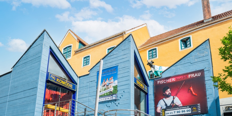 Eingang des Packhaustheaters im Schnoor in Bremen mit blauer Fassade und Veranstaltungsplakaten