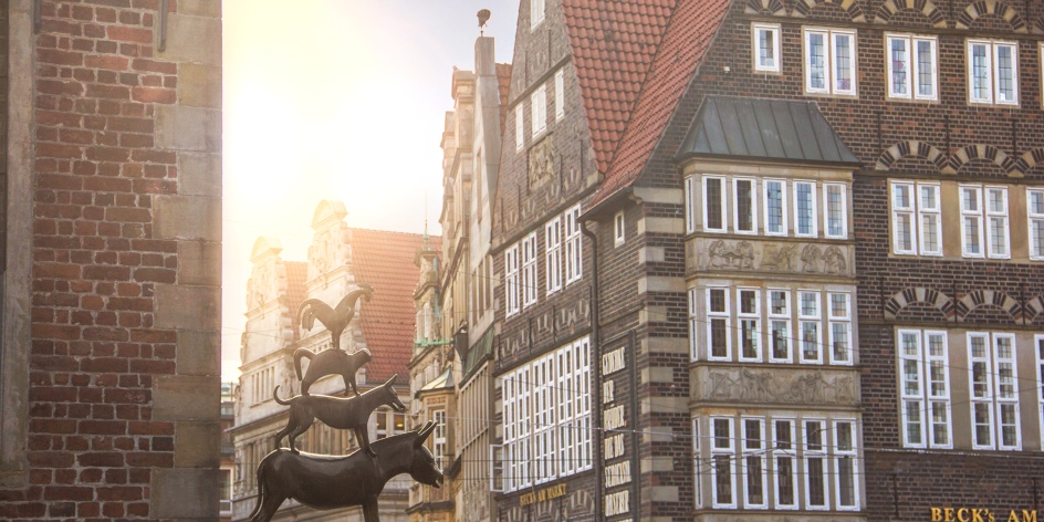 In the left part of the picture you can see the Bremen Town Musicians. In the right part a historical building.