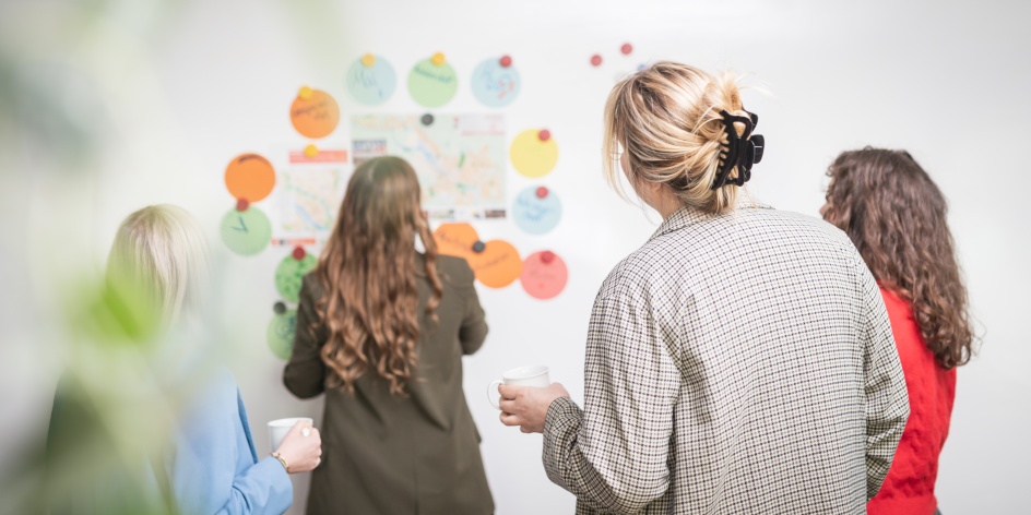 Vier Frauen stehen vor einem Whiteboard und erarbeiten ein Thema zusammen