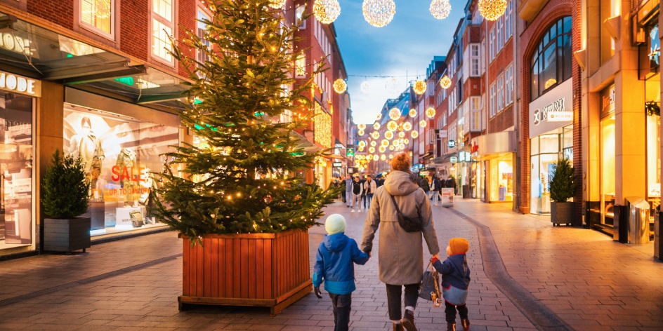 Eine Familie schlendert durch die weihnachtlich beleuchtete Sögestraße