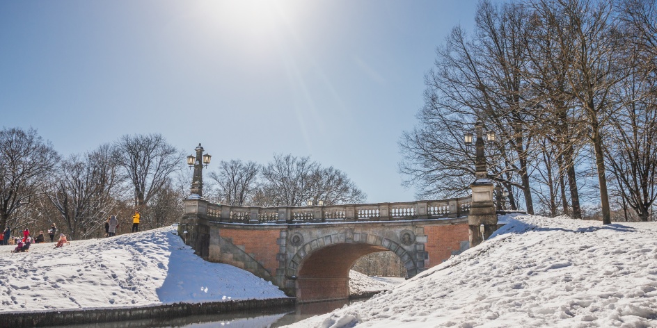 Eine Brücke die über einen kleinen Bach im Bürgerpark führt. Es liegt Schnee.